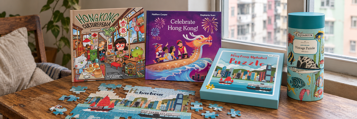 Hong Kong books and puzzles with loose pieces on a wooden table in a Hong Kong home.