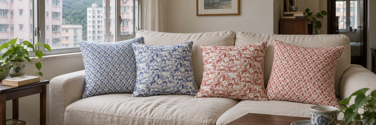 Four blue and red Thorn and Burrow cushions on a linen sofa in a Hong Kong apartment