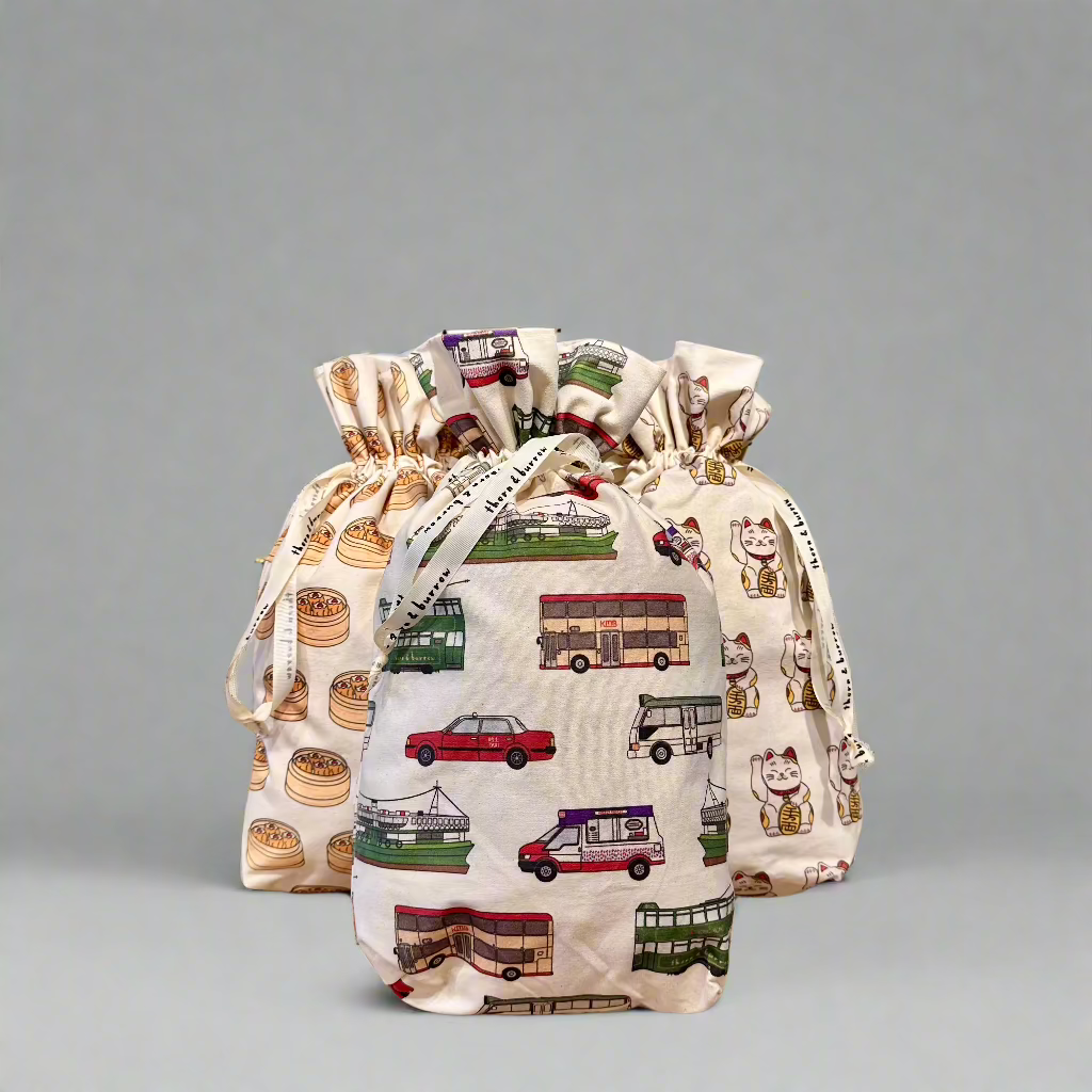 Three reusable drawstring gift bags with lucky cat, dim sum and Hong Kong transport patterns.