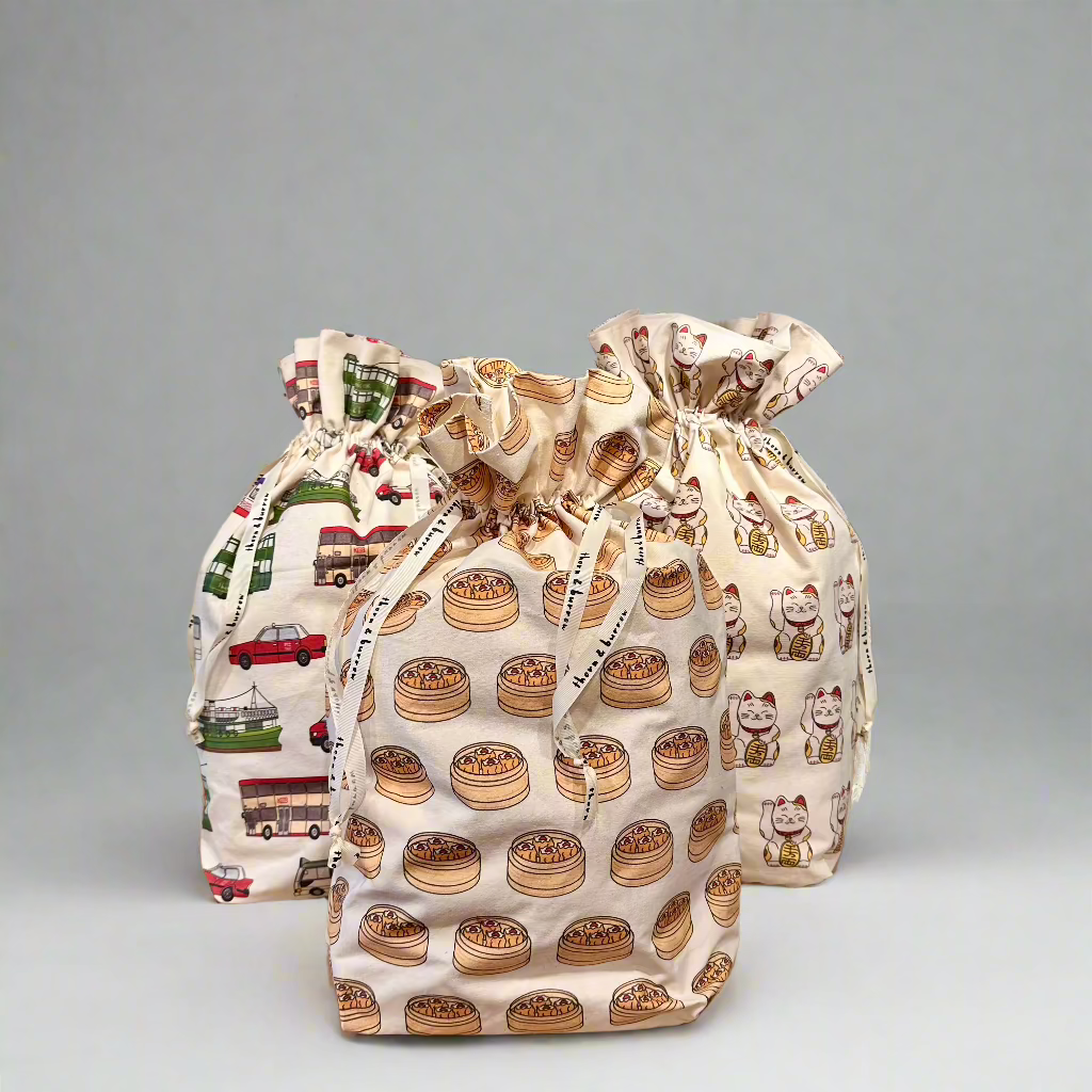 A group of reusable cotton gift bags showing dim sum baskets, lucky cats and Hong Kong transport.
