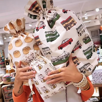 Reusable Hong Kong cotton gift bags in dim sum, lucky cat and transport prints, held together in a shop.