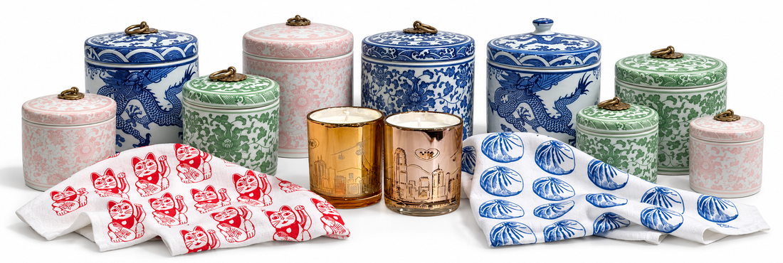 Chinese ceramic storage jars, Lucky Cat and Baozi tea towels, and Hong Kong Skyline candles on white